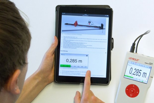 Ein Schüler führt eine Messung mit dem Schülermessgerät Mobile-CASSY 2 WLAN durch. Diese wird in Echtzeit in der interaktiven, digitalen Versuchsanleitung Lab Docs ausgegeben.
