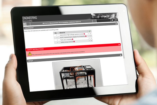 Tablet mit digitaler Versuchsanleitung des Hochvolt-Trainers in der Kfz-Technik