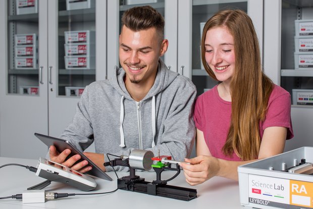 Zwei Schüler*innen führen einen Science Lab Schülerversuch aus dem Bereich der Physik durch. Sie experimenten in der Atom- und Kernphysik zum Thema Umweltradioaktivität. Dabei werden digitale Medien wie ein Tablet und das Schülermessgerät Mobile-CASSY 2 WLAN verwendet. 