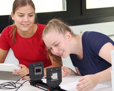 Zwei Schülerinnen des Pestalozzi-Gynmasiums in Unna experimieren mit den Science Lab Schülerversuchen im Bereich der Optik. Die Messwerterfassung erfolgt mit dem Schülermessgerät Mobile-CASSY-2 WLAN und der digitalen Versuchsanleitung Lab Docs auf einem Tablet. 