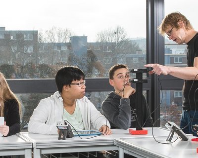 Die Gesamtschule Hürth arbeiten im Physikunterricht mit dem Schülerversuchesystem Science Lab. Im Themengebiet Mechanik experimentieren Schülerinnen und Schüler zum Thema "Freier Fall". Die Lehrkraft gibt Hilfestellung bei Fragen.