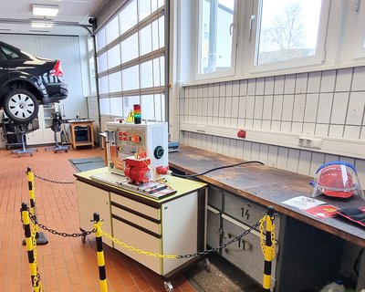 In der Werkstatt des Berufskollegs Wittgenstein Bad Berleburg wird in einer realen Umgebung das Freischneiden eines E-Autos mit dem Hochvoltsystem Trainer erlernt.